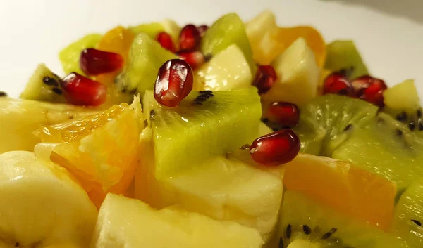 fruit salad banana, kiwi, orange, pomegranate background, antioxidant