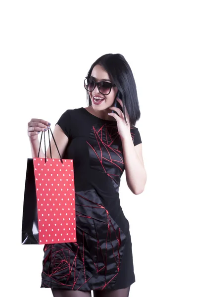 Красивая девушка с телефоном платье очки пакет — стоковое фото