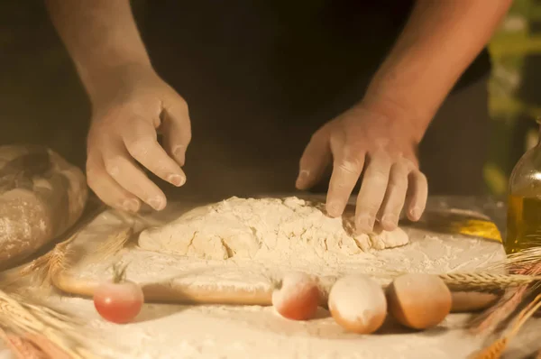 male baker hands, kneads dough