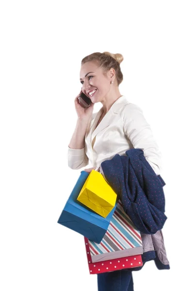 Молодая женщина с телефоном и покупки изолированы — стоковое фото