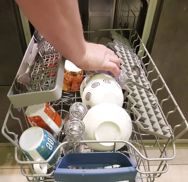 man is loading dishes in the dishwasher house