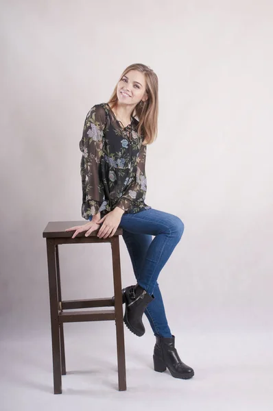 Piękne Dziewczyny Dżinsy Siedzi Studio Krzesełko — Zdjęcie stockowe