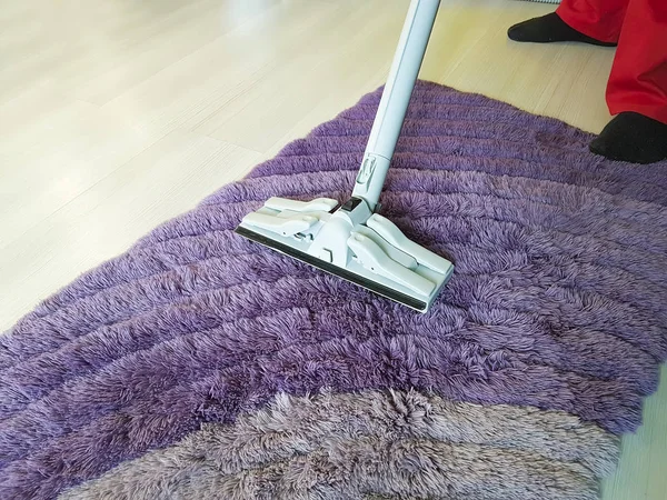 man vacuuming the carpet in the room