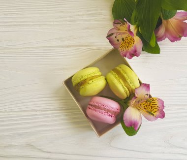 Beyaz ahşap zemin, alstroemeria çiçek üzerine bir kutu içinde Macaron