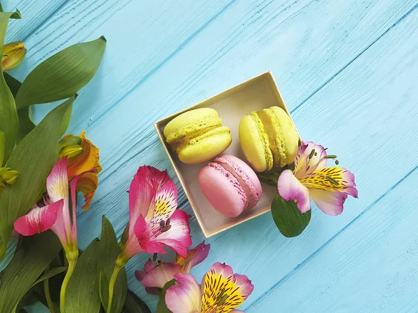 Macaron Een Vak Een Blauwe Achtergrond Van Houten Alstroemeria Bloem — Stockfoto