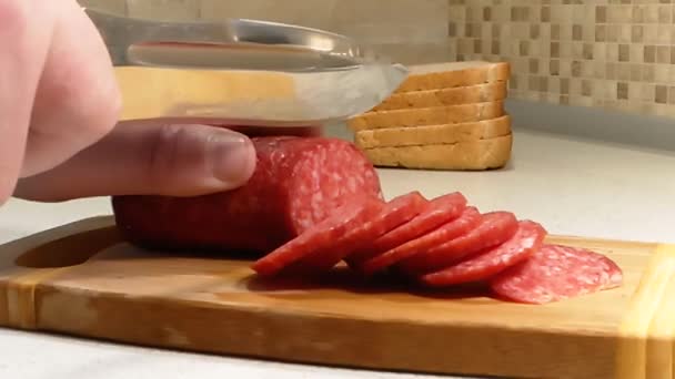 Hände Schneiden Wurst Auf Einem Holzbrett — Stockvideo