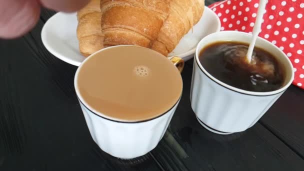 牛奶倒入一杯咖啡 一个羊角面包 — 图库视频影像