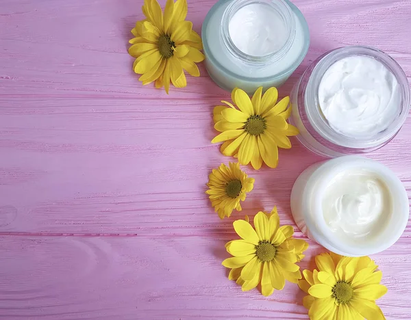 Creme Cosméticos Flores Amarelas Fundo Madeira Rosa — Fotografia de Stock