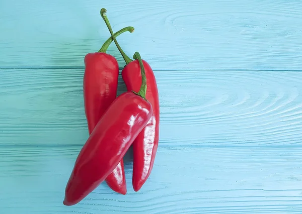 Mavi ahşap üzerinde kırmızı biber