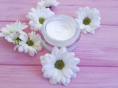 bir pembe ahşap üzerinde kozmetik krem beyaz çiçekler