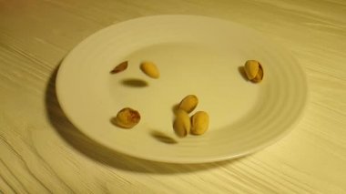 Beyaz ahşap plaka, damla, ağır çekim çekim Antep fıstığı