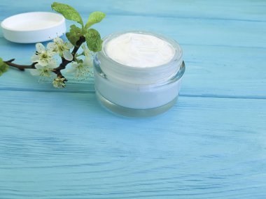 krem kozmetik, kiraz dal ahşap arka plan mavi çiçek