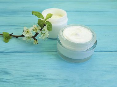 krem kozmetik, kiraz dal ahşap arka plan mavi çiçek