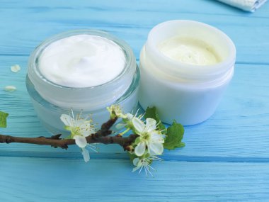 krem kozmetik, kiraz dal ahşap arka plan mavi çiçek