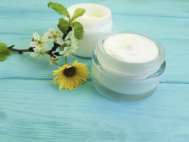 krem kozmetik, kiraz dal ahşap arka plan mavi çiçek