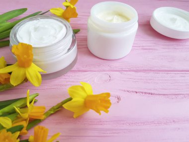 Nergis kozmetik krem bir pembe ahşap üzerinde