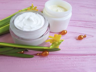 Nergis krem pembe ahşap üzerinde kozmetik kapsül