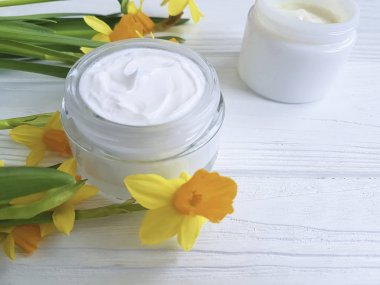 Beyaz tahta üzerine krem kozmetik nergis el yapımı