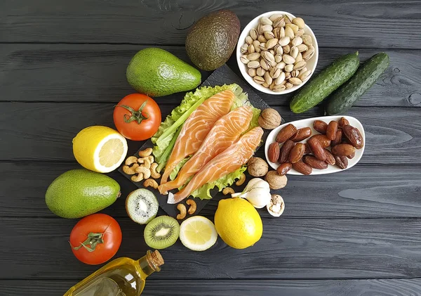 red fish, avocado nuts on black wooden, healthy food,