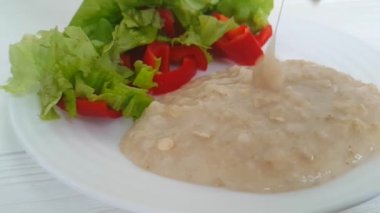 yulaf lapası bir tabak salata üzerinde