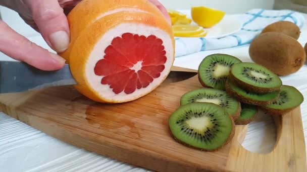 Hände Mit Einem Messer Grapefruit Auf Einem Hölzernen Geschnitten — Stockvideo