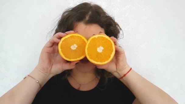 Chica Llena Una Naranja Sostiene Cerca Los Ojos — Vídeos de Stock