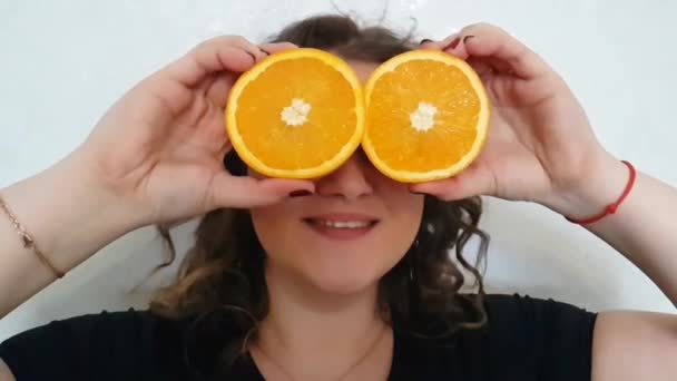 Chica Llena Una Naranja Sostiene Cerca Los Ojos — Vídeo de stock