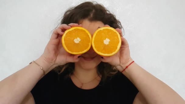 Chica Llena Una Naranja Sostiene Cerca Los Ojos — Vídeo de stock