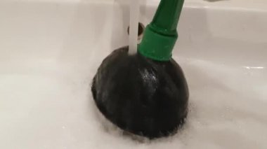 Dalgıç tıkanmış lavabo kaldırmak için çalışıyor