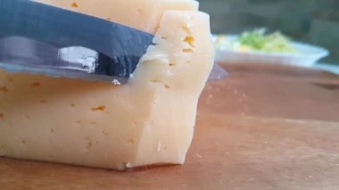 peynir bir ahşap tahta üzerinde bir bıçak ile kesmek