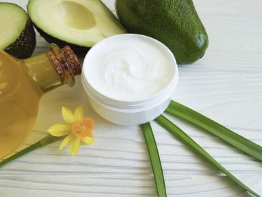 bir beyaz tahta üzerine krem kozmetik avokado