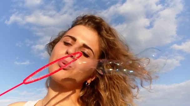 シャボン玉スローモーション撮影を吹いている海の上の美しい女性 — ストック動画