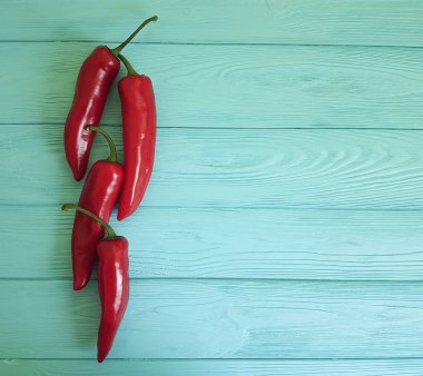 Mavi ahşap arka plan üzerinde kırmızı biber