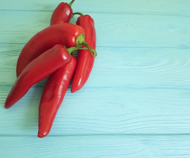 Mavi ahşap arka plan üzerinde kırmızı biber