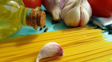 spagetti, bir şişe, sarımsak, domates, karabiber mavi ahşap arka plan, ağır çekim çekim üzerine yağda