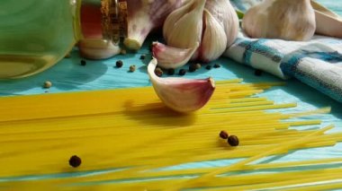 spagetti, bir şişe, sarımsak, domates, karabiber mavi ahşap arka plan, ağır çekim çekim üzerine yağda