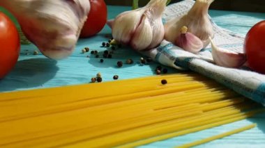 spagetti, bir şişe, sarımsak, domates, karabiber mavi ahşap arka plan, ağır çekim çekim üzerine yağda