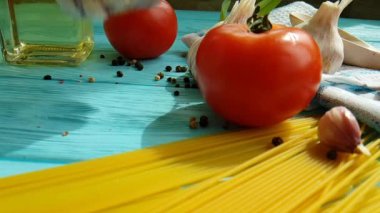 spagetti, bir şişe, sarımsak, domates, karabiber mavi ahşap arka plan, ağır çekim çekim üzerine yağda