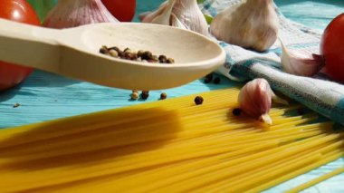 spagetti, bir şişe, sarımsak, domates, karabiber mavi ahşap arka plan, ağır çekim çekim üzerine yağda
