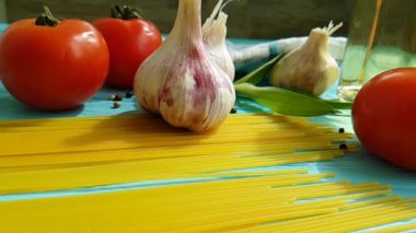 spagetti, bir şişe, sarımsak, domates, karabiber mavi ahşap arka plan, ağır çekim çekim üzerine yağda