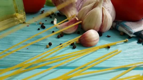 Spaghetti Olja Flaska Vitlök Tomat Svartpeppar Blå Trä Bakgrund Slowmotion — Stockvideo