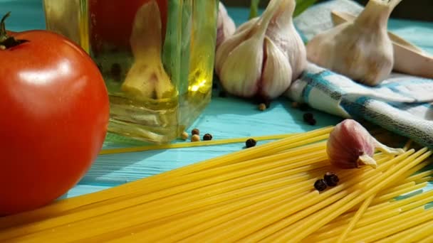 Spaghetti Oil Bottle Garlic Tomato Black Pepper Blue Wooden Background — Stock Video