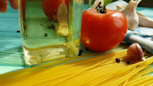 Spaghetti Olja Flaska Vitlök Tomat Svartpeppar Blå Trä Bakgrund Slowmotion — Stockvideo