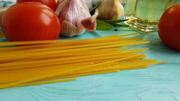 Spaghetti Oil Bottle Garlic Tomato Black Pepper Blue Wooden Background — Stock Video