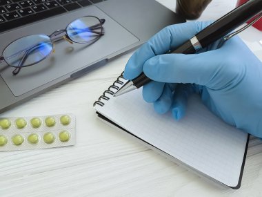 el eldiven içinde bir doktor yazıyor masaüstü, dizüstü bilgisayar