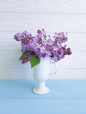 Leylak bir tahta üzerinde bir vazoda buket