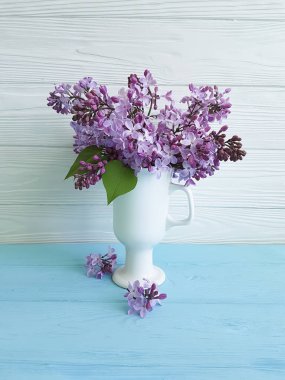 Leylak bir tahta üzerinde bir vazoda buket