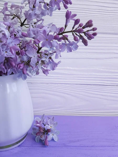 bouquet of lilac in a vase on a wooden background, spring