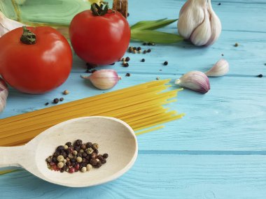 Spagetti kurutulmuş domates sarımsak, biber, mavi ahşap arka planda yağ