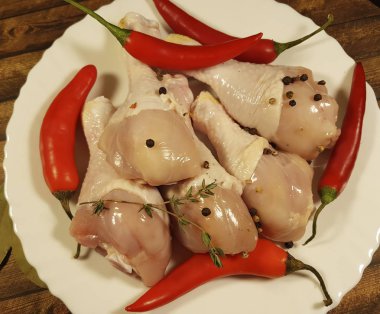 çiğ tavuk ayakları üzerinde bir tabak kırmızı biber